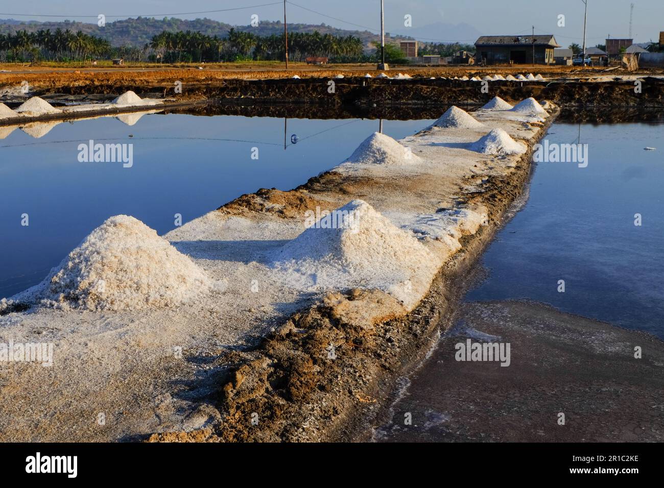 Il processo di cristallizzazione dell'acqua di mare in sale in modo tradizionale in Indonesia. Foto Stock