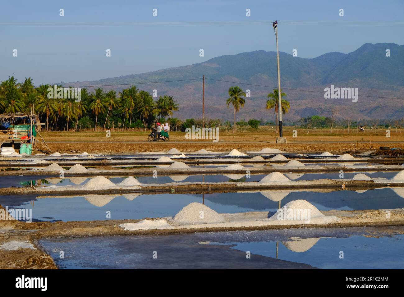 Il processo di cristallizzazione dell'acqua di mare in sale in modo tradizionale in Indonesia. Foto Stock