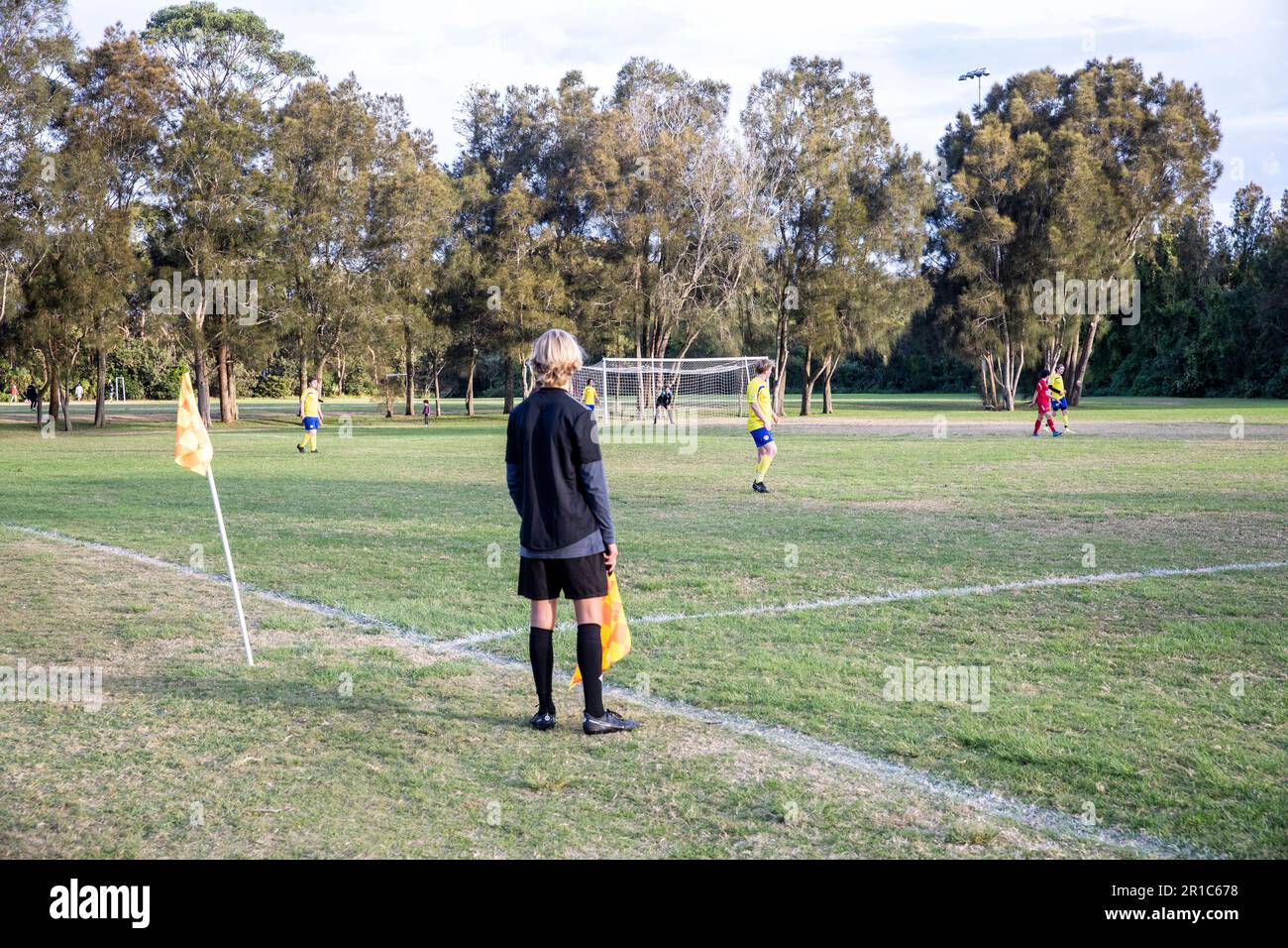 GrassRoots football, giovane uomo di linea o arbitri assistente che corrono la linea ad una partita di calcio maschile, Sydney, NSW, Australia Foto Stock