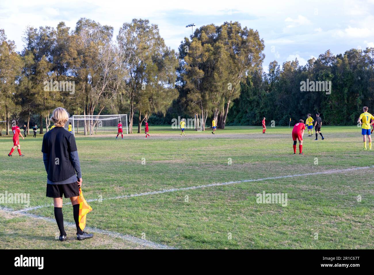 GrassRoots football, giovane uomo di linea o arbitri assistente che corrono la linea ad una partita di calcio maschile, Sydney, NSW, Australia Foto Stock