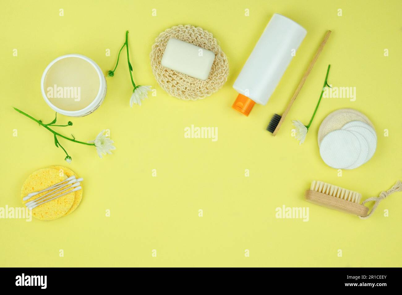 Salviette, shampoo e altri accessori su sfondo giallo. Spazio di copia. Vista dall'alto. Foto Stock