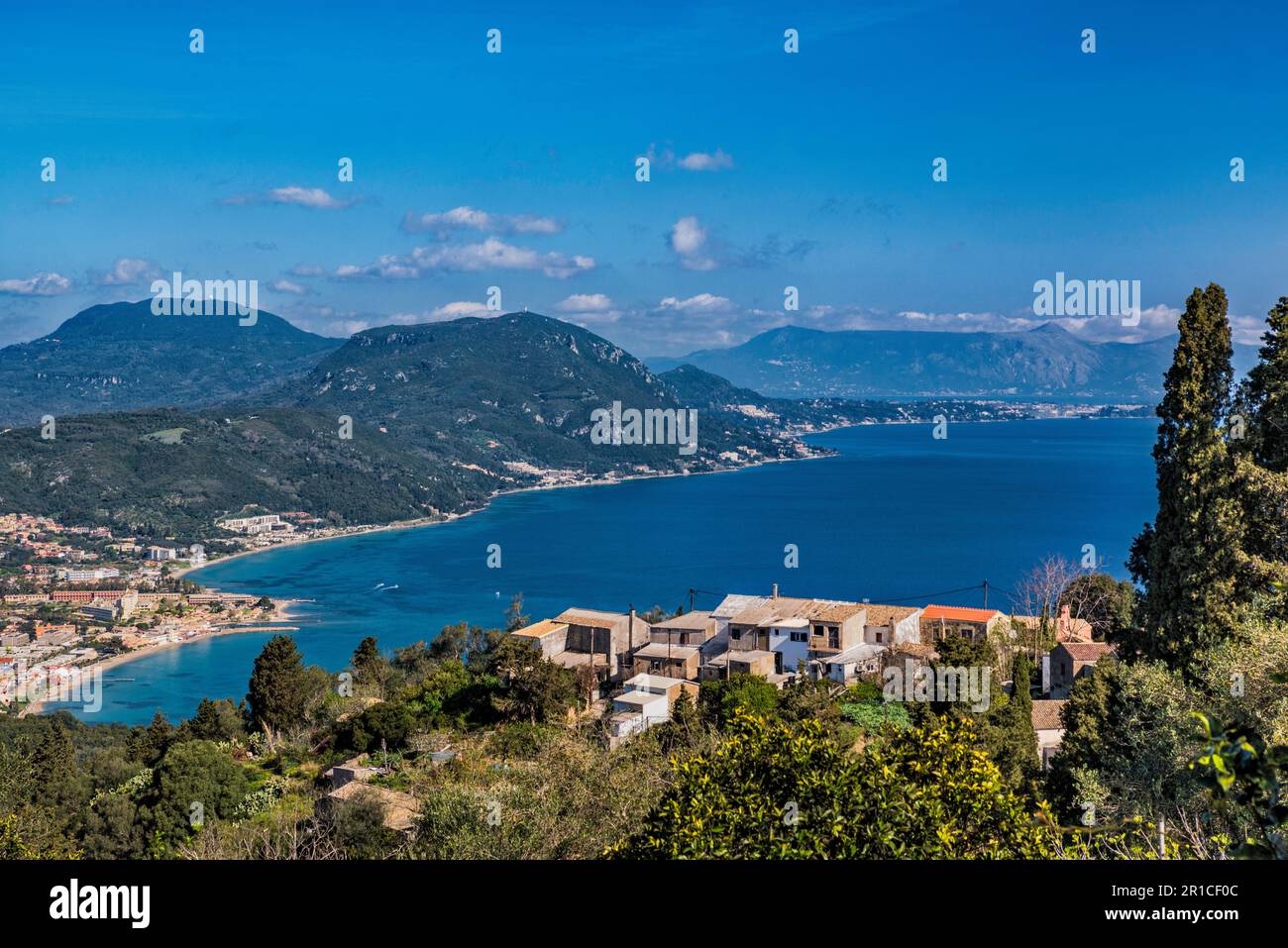 Costa del Mar Ionio, con la città di Moraitika e la città di Corfù e le montagne albanesi in lontananza, dalla strada locale vicino a Chlomos, Corfù isola, Grecia Foto Stock