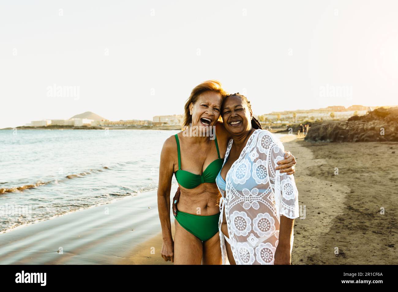 Donne multirazziali anziane felici che si divertono sulla spiaggia durante le vacanze estive - amici anziani diversi godendo le vacanze Foto Stock