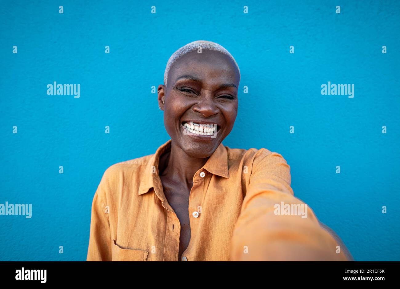 Felice donna africana che si diverte a prendere selfie con la fotocamera per smartphone all'aperto Foto Stock