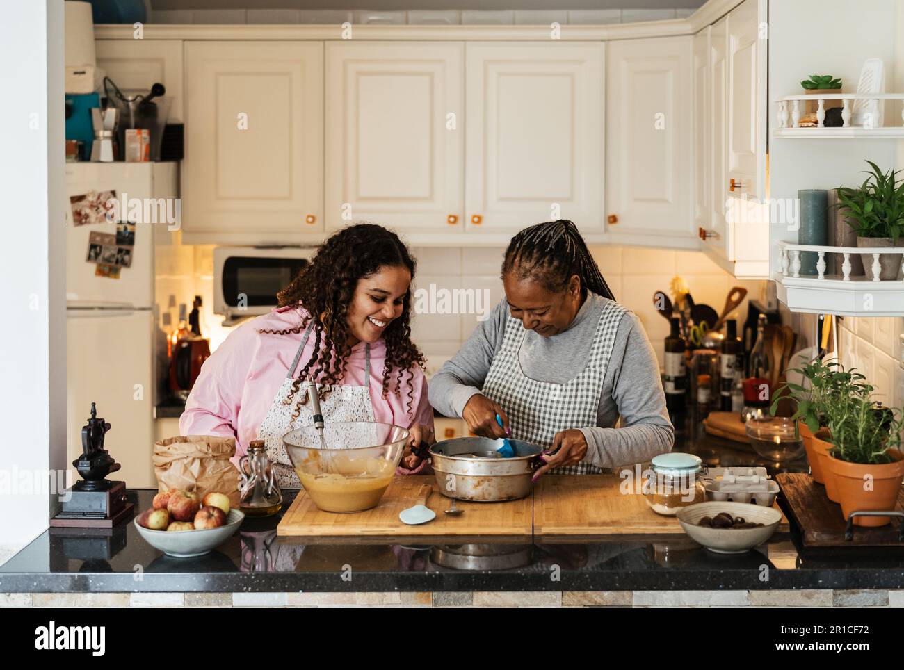 Felice madre africana e figlia che si divertono a preparare un dessert fatto in casa Foto Stock
