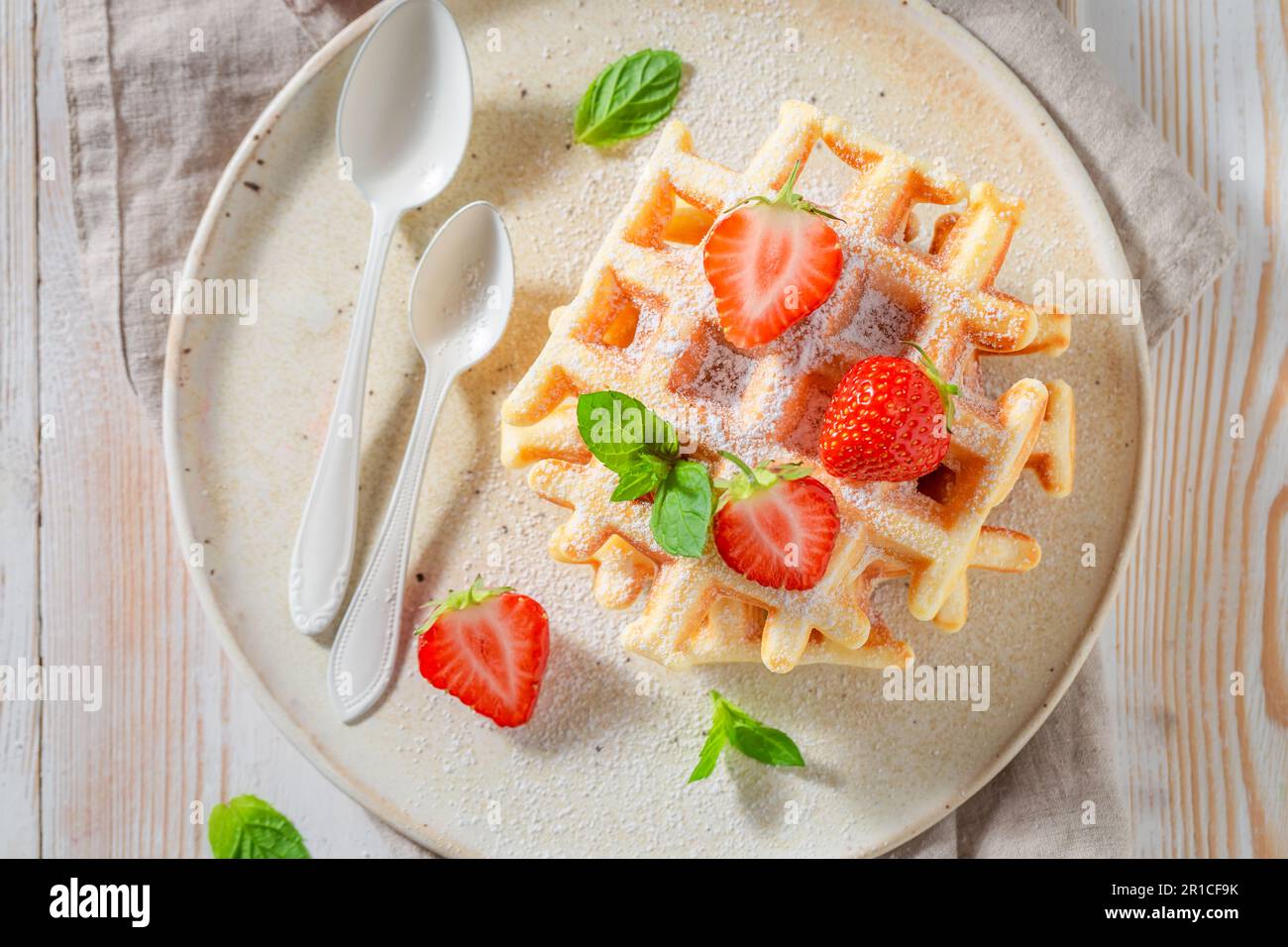 Wafer fatti in casa e freschi con fragole e menta. Cialde con fragole e zucchero a velo. Foto Stock