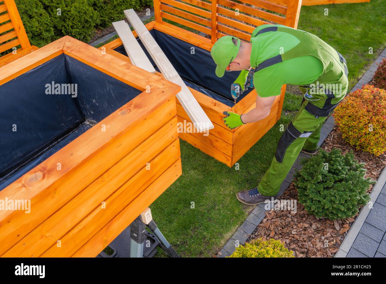 Uomo caucasico costruzione di grandi piantatrici di legno su misura per il suo giardino sul retro Foto Stock