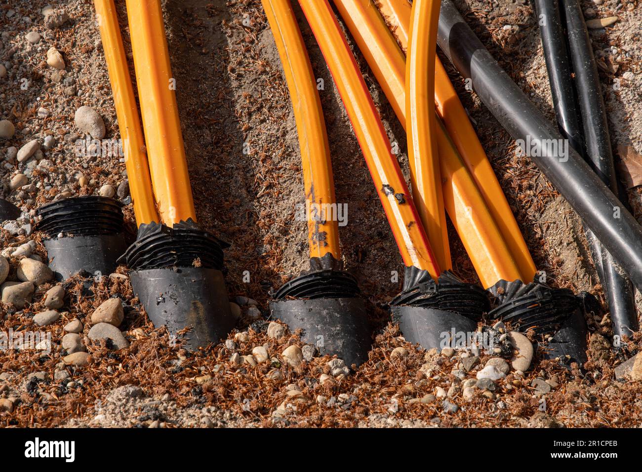 Il cavo in fibra ottica e il teleriscaldamento sono disposti nel cavo arancione della strada Foto Stock