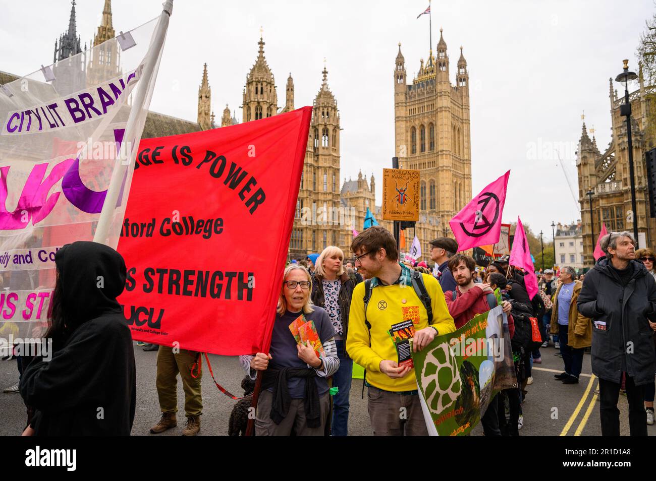 LONDRA - 22 aprile 2023: Sperimentate la forza collettiva mentre i manifestanti marciano davanti alle Camere del Parlamento durante la dimostrazione XR, alzando il Foto Stock