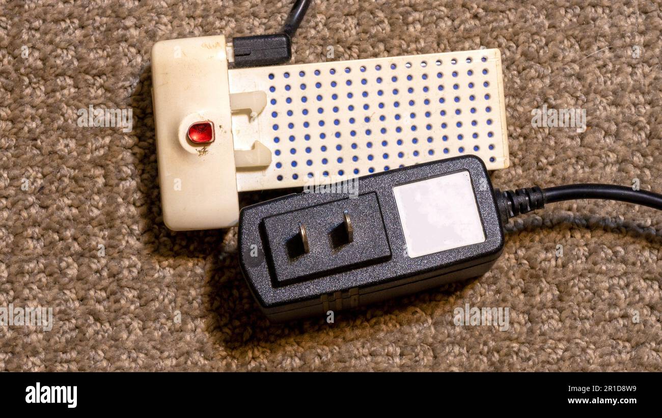 Una batteria al litio e un caricabatteria da 120 V. Foto Stock