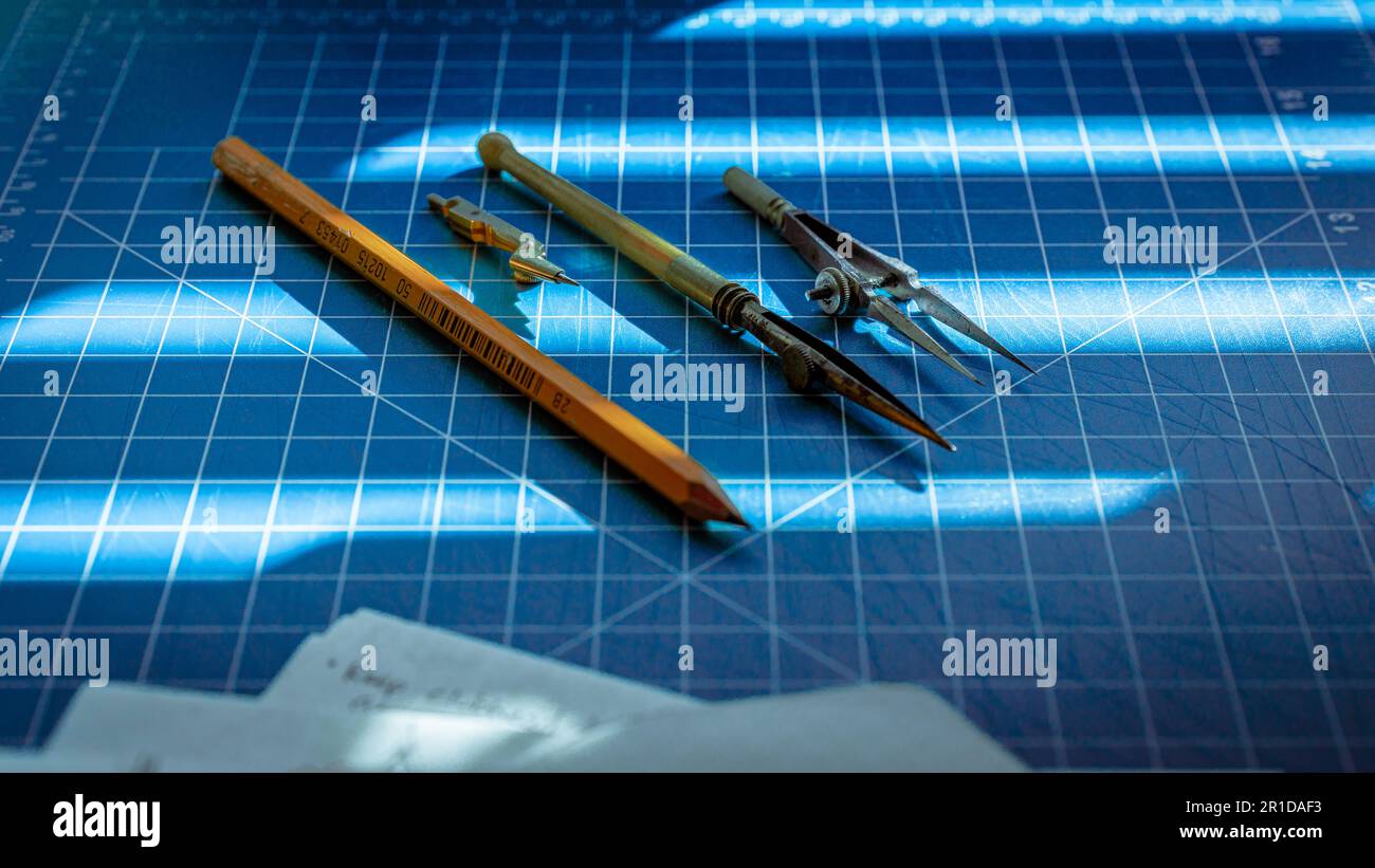 Un assortimento di strumenti da disegno vintage disposti su un tappeto di taglio Foto Stock