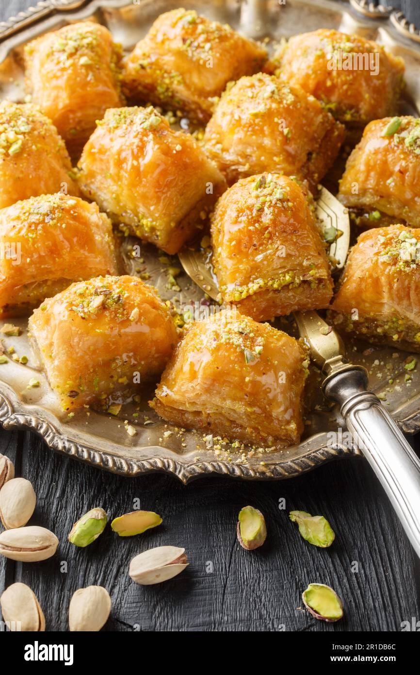 Sapori tradizionali mediorientali Pistacchio baklava o fistikli baklava primo piano sul piatto del tavolo di legno. Verticale Foto Stock