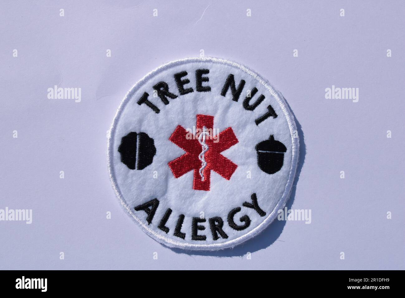 Allergia alla noce d'albero cucire sulla patch su uno sfondo semplice con spazio di copia. Lancashire, Regno Unito, 13-05-2023 Foto Stock