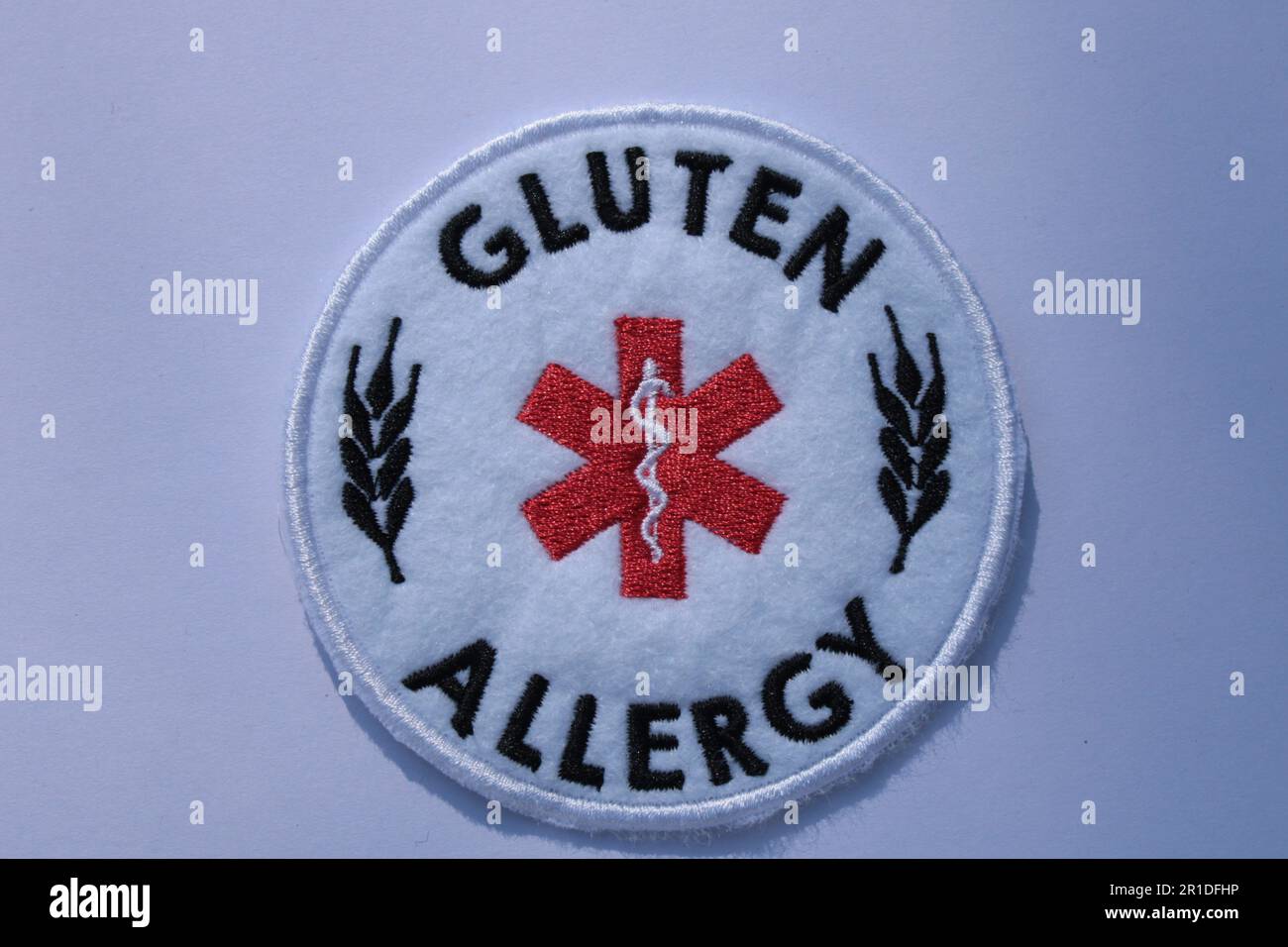 Allarme di allergia al glutine cucire su un cerotto su uno sfondo semplice. Lancashire, Regno Unito, 13-05-2023 Foto Stock