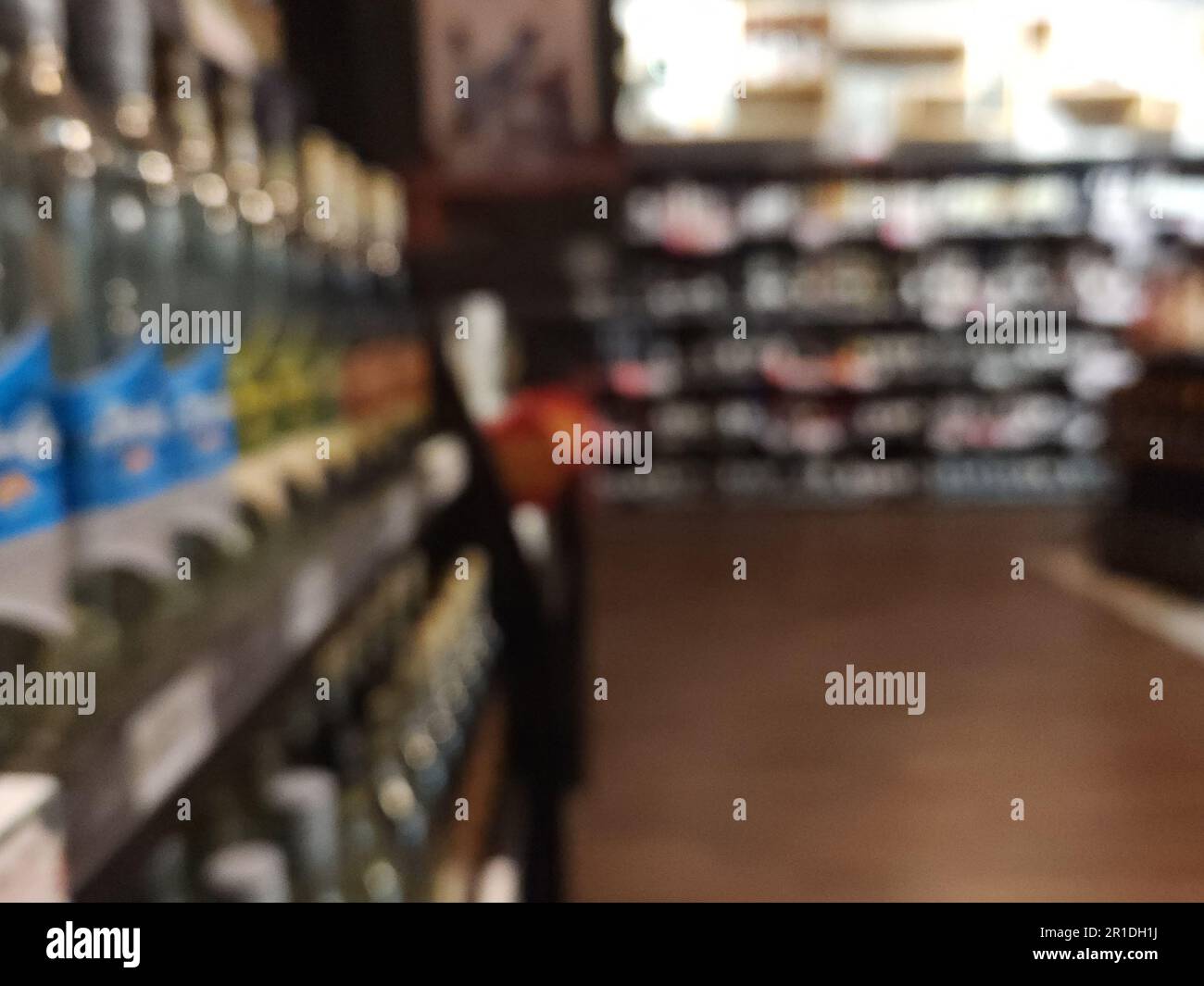 Negozio di liquori sfondo sfocato. Scaffale con alcol in magazzino Foto Stock