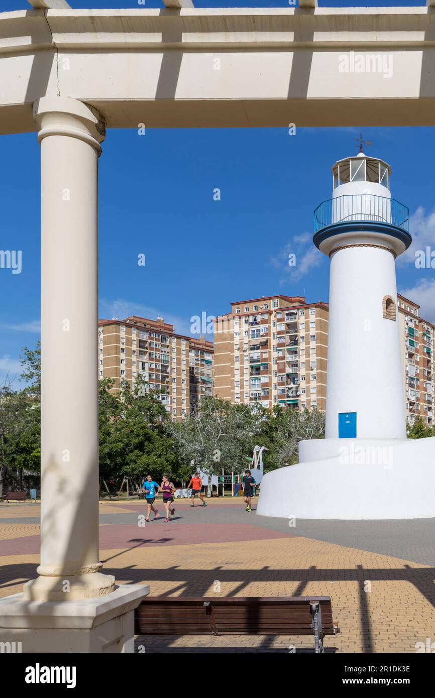 Corridori che passano il faro nel Parque de Huelin o nel Parco Huelin, Malaga, Costa del Sol, Provincia di Malaga, Andalusia, spagna meridionale. Huelin è un bar Foto Stock