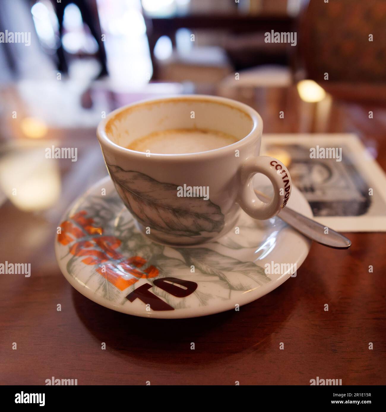 Tazza di cappuccino mezzo bevuto su un tavolo in un caffè Foto Stock