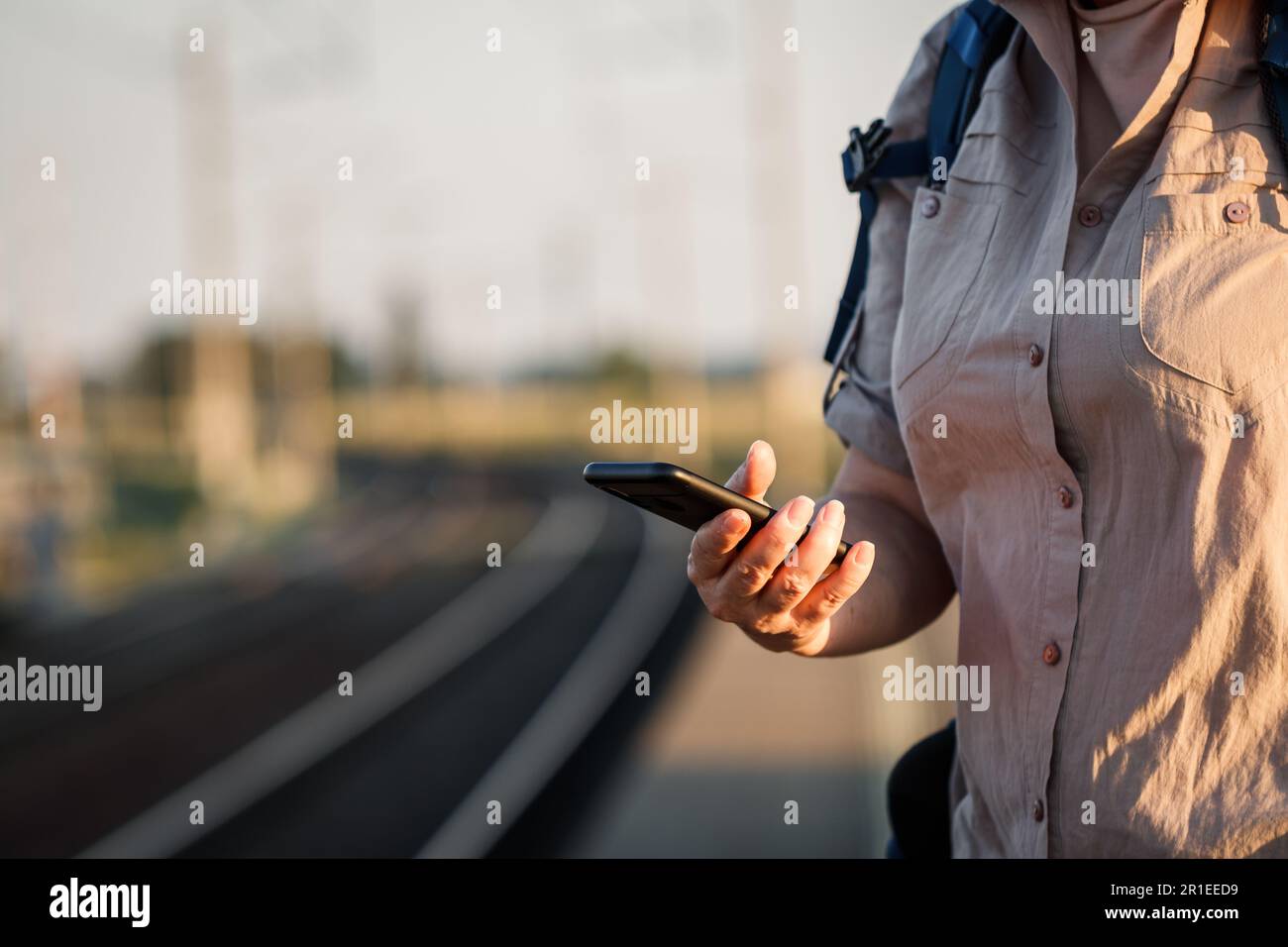 Donna che acquista un biglietto ferroviario online per allenarsi con l'app mobile sul suo smartphone Foto Stock