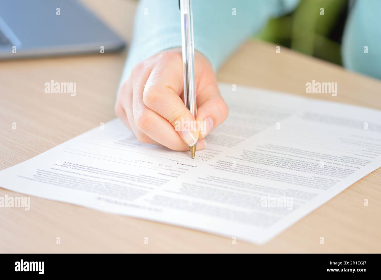 In prossimità di una donna la scrittura a mano o la firma di un documento sulla scrivania a casa o in ufficio Foto Stock