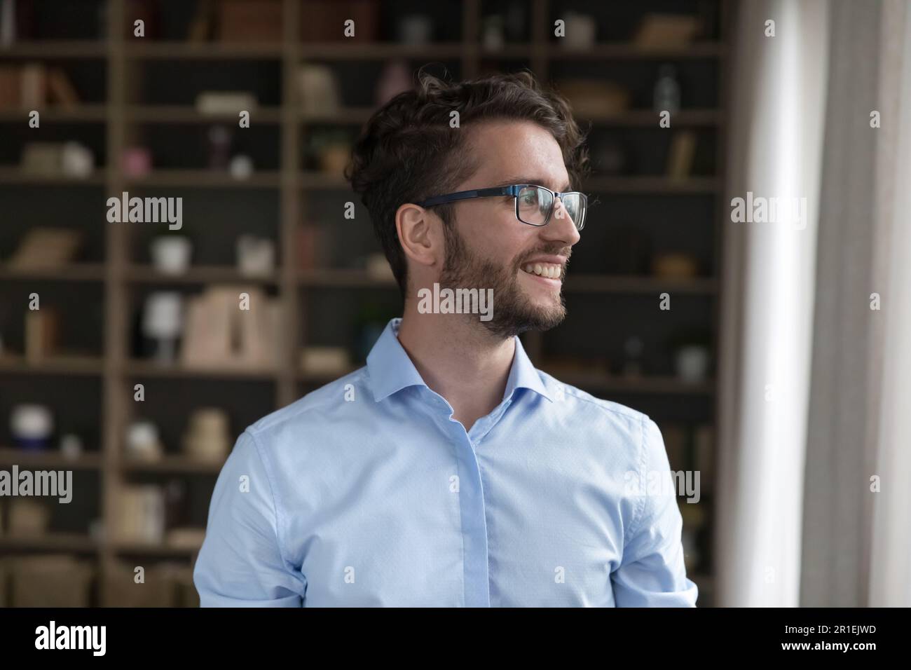 Uomo d'affari giovane da sogno positivo in occhiali alla moda Foto Stock