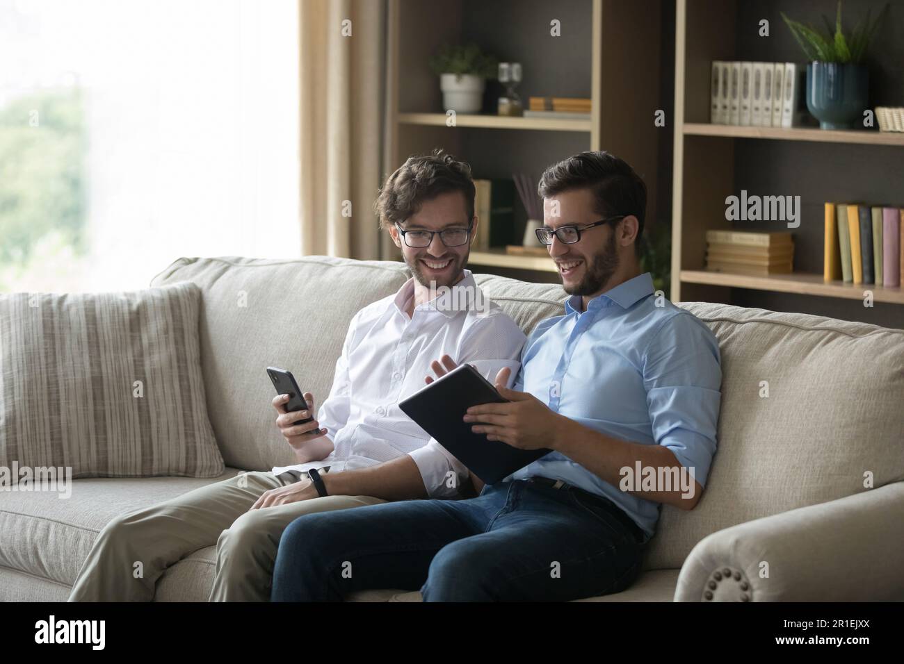 Uomini felici del fratello gemello che discutono il progetto riuscito di affari Foto Stock