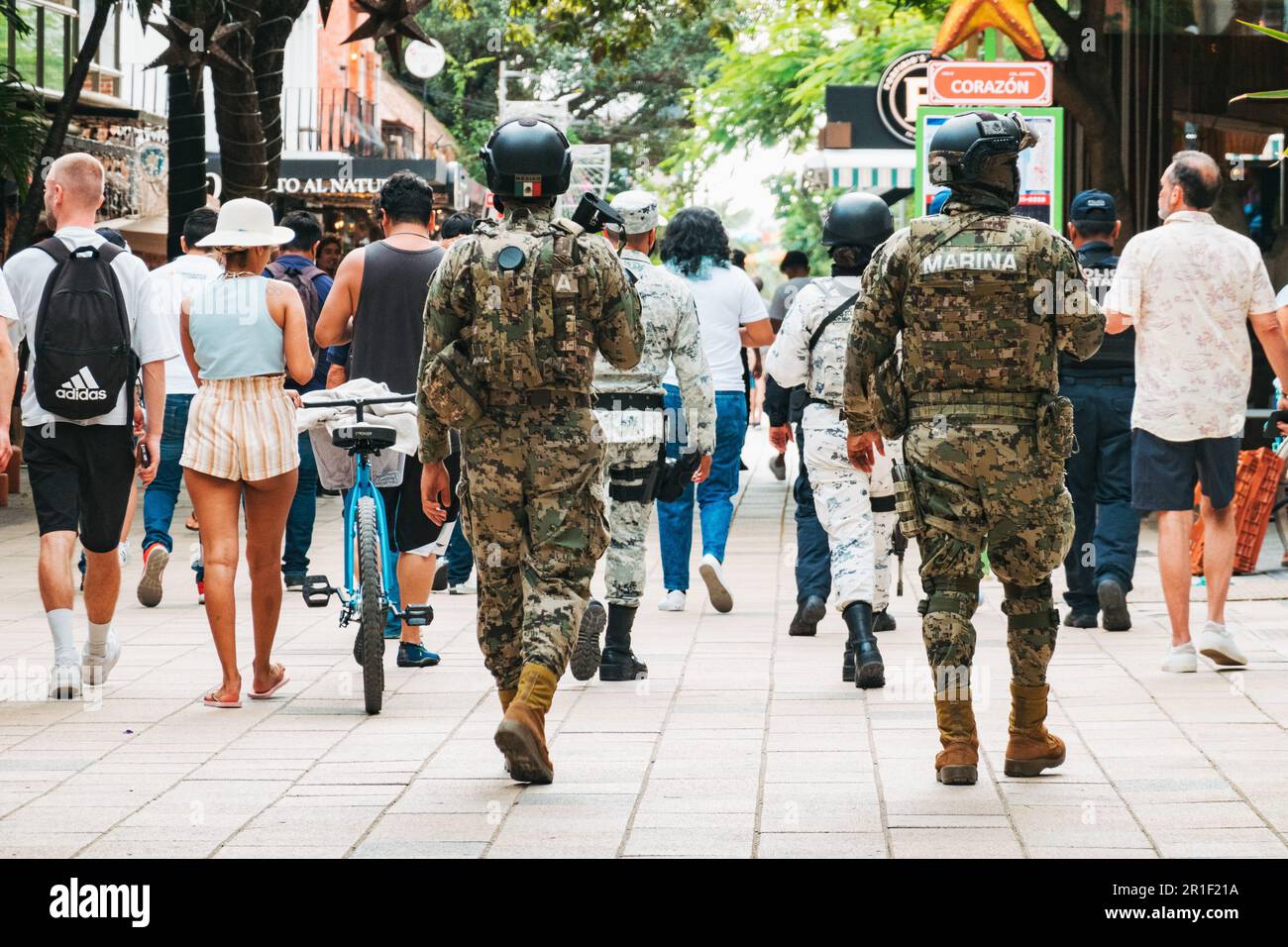 Le truppe della Marina messicana camminano tra i turisti lungo il centro commerciale pedonale la Quinta Avenida a Playa del Carmen, Quintana Roo, Messico Foto Stock