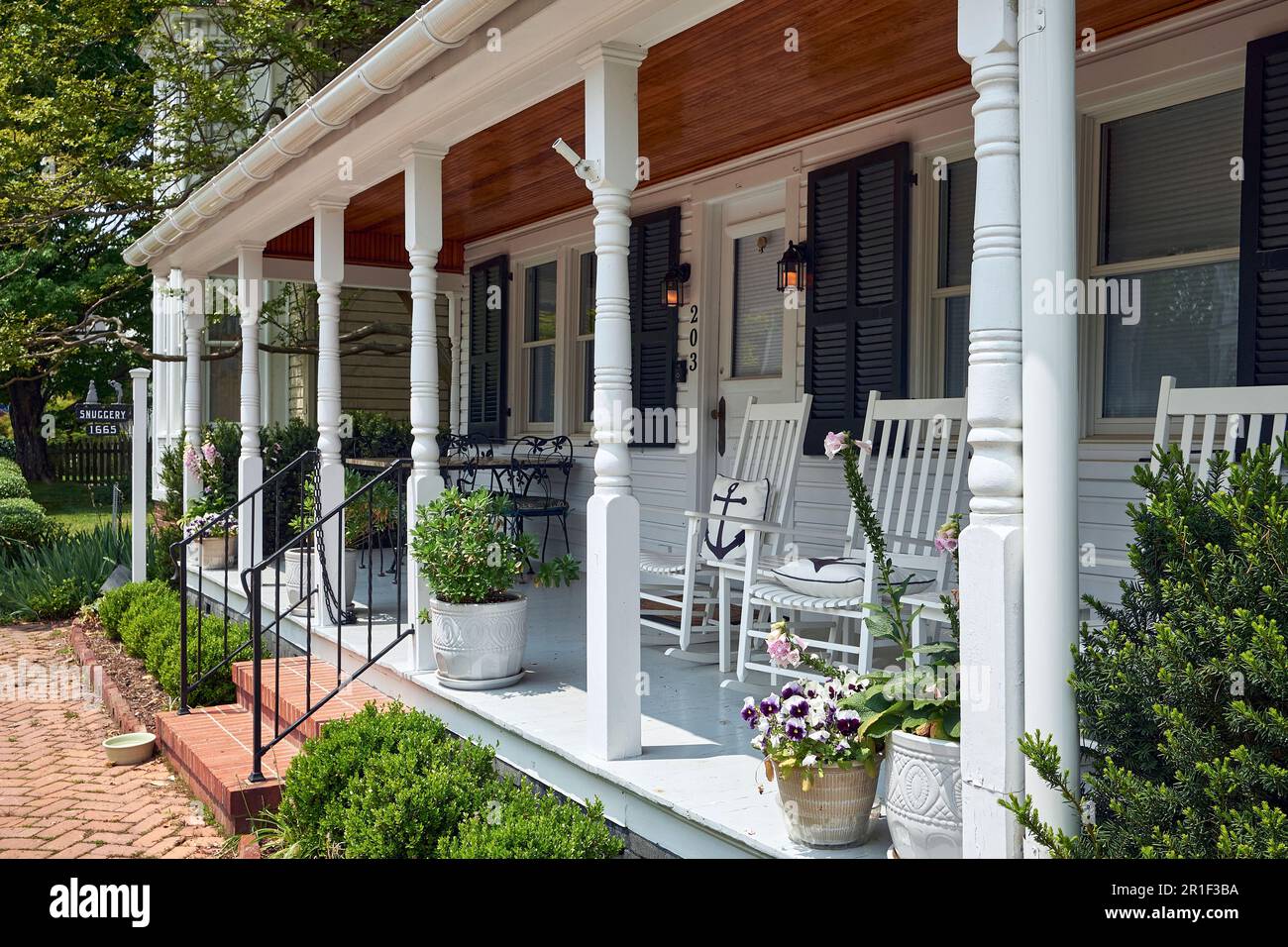 Un comodo portico bianco con sedie a dondolo nella cittadina di St Michaels, Maryland. STATI UNITI. Foto Stock