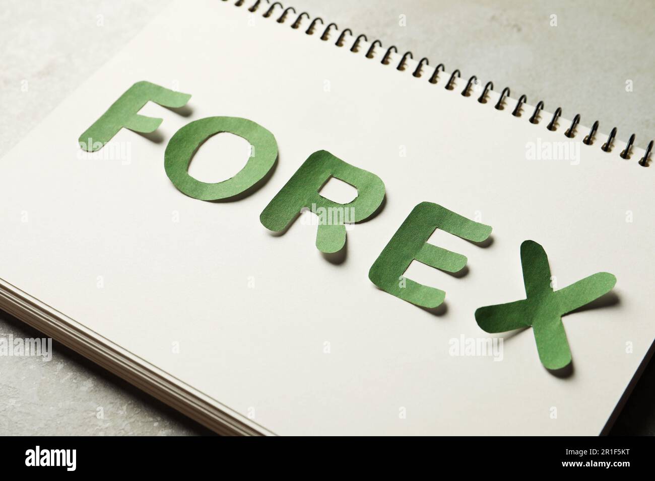 Quaderno con parola Forex fatto di lettere verdi su tavolo grigio Foto Stock