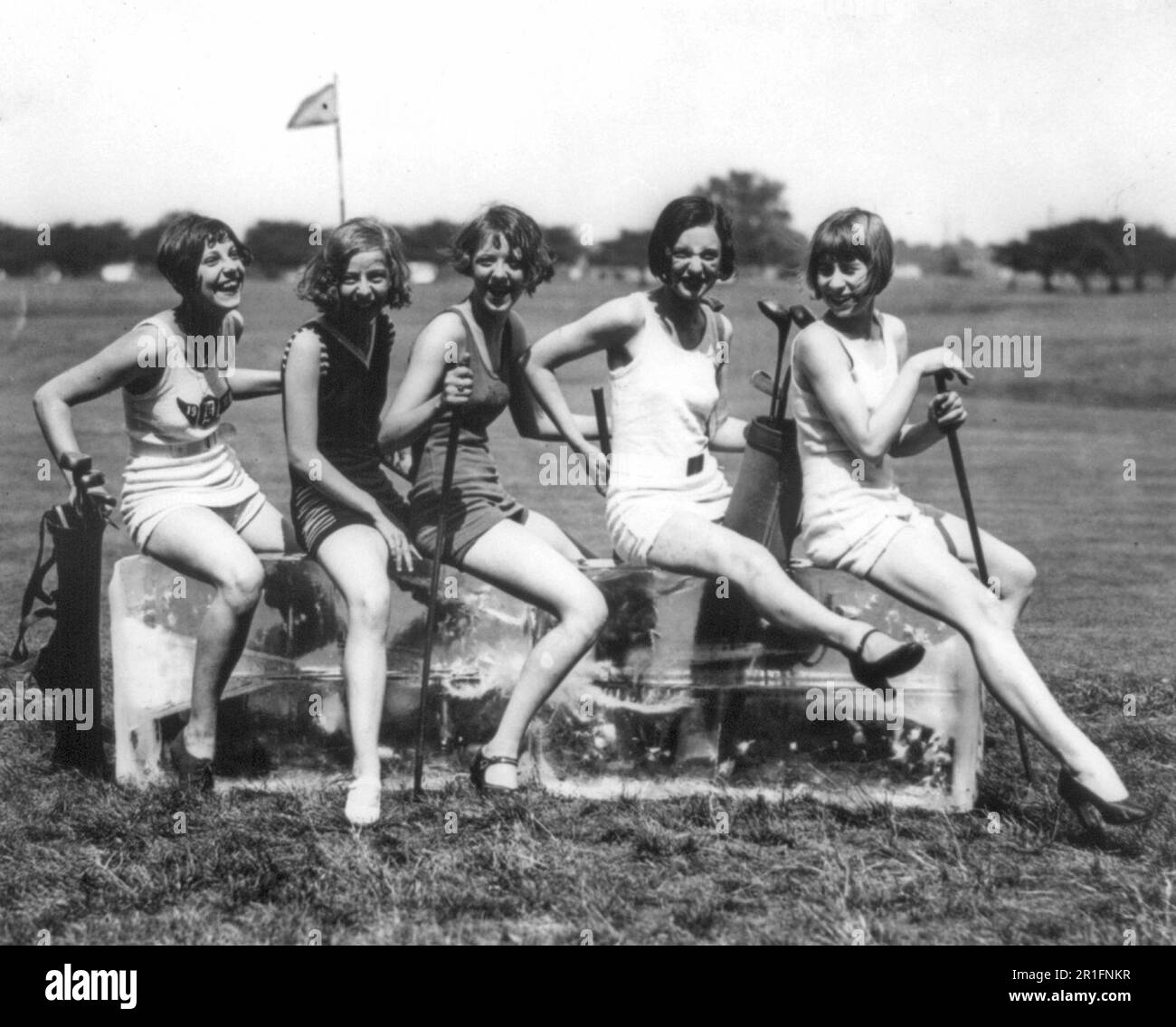 Foto di archivio: Donne su un campo da golf seduto su blocchi di ghiaccio. Dorothy Kelly, Virginia Hunter, Elaine Griggs, Hazel Brown e Mary Kaminsky in costume da bagno seduti su due grandi blocchi di ghiaccio ca. 1920-1932 Foto Stock