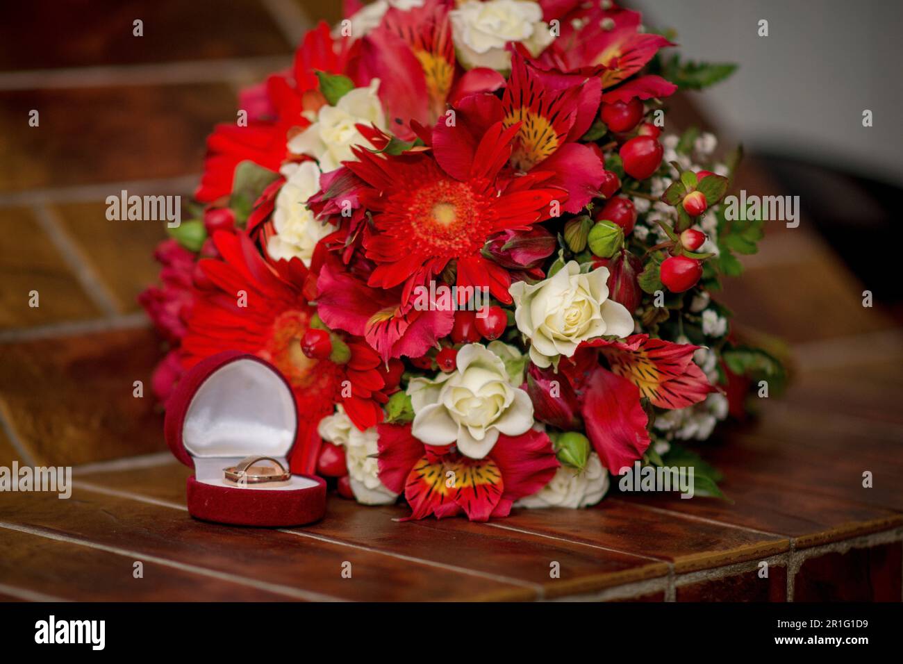 anelli della sposa e sposo accanto ad un bouquet di fiori. primo piano Foto Stock