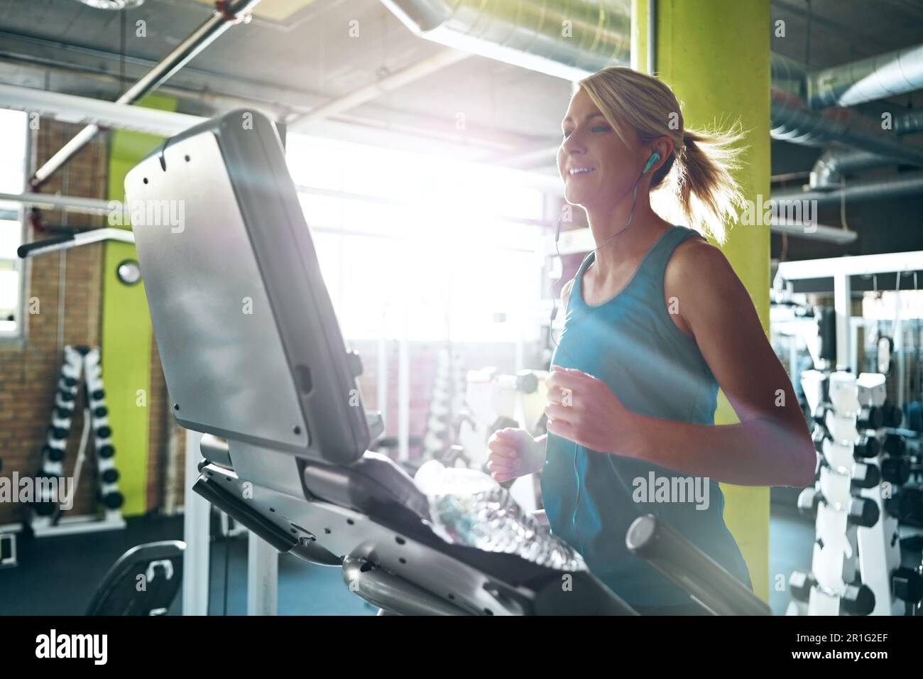 Corri fino a quando il tapis roulant diventa troppo lento. una giovane donna che lavora sul tapis roulant in palestra. Foto Stock