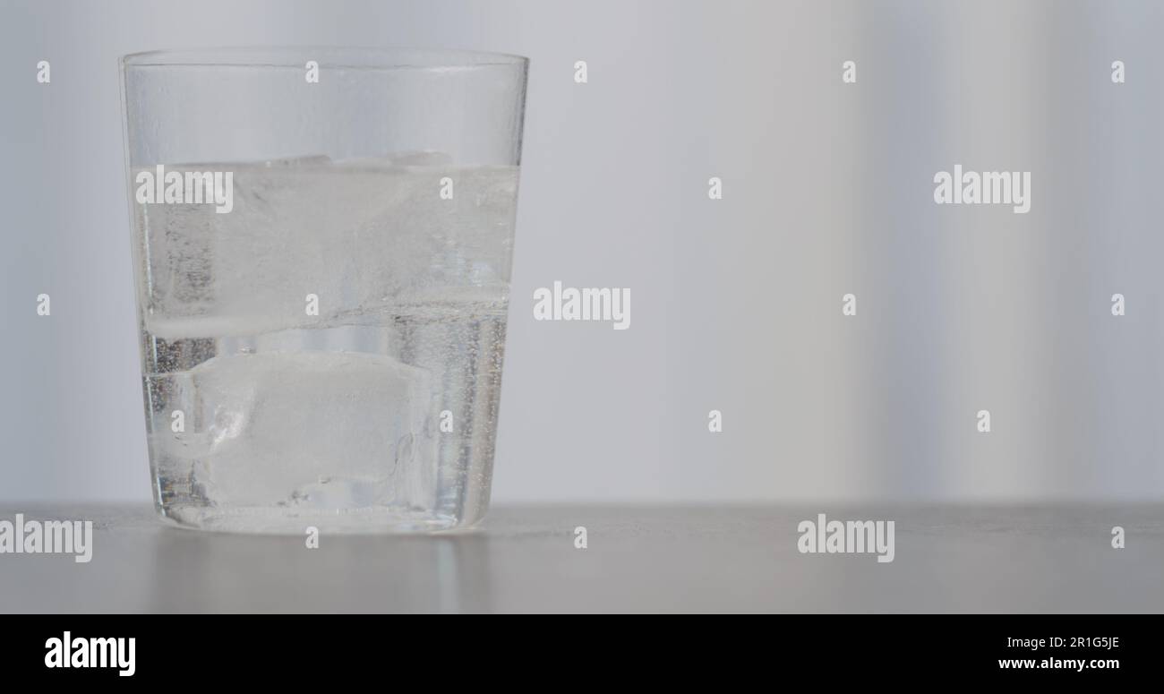 pulire il bicarbonato o il tonico nel bicchiere con ghiaccio su un piano di appoggio in calcestruzzo con spazio di copia, foto ampia Foto Stock
