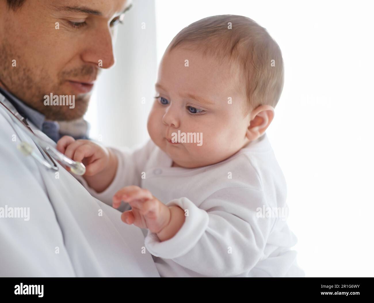 Medico, pediatra e bambino che gioca con stetoscopio per la valutazione sanitaria, supporto medico e la crescita. Servizio neonati, uomo e pediatria Foto Stock