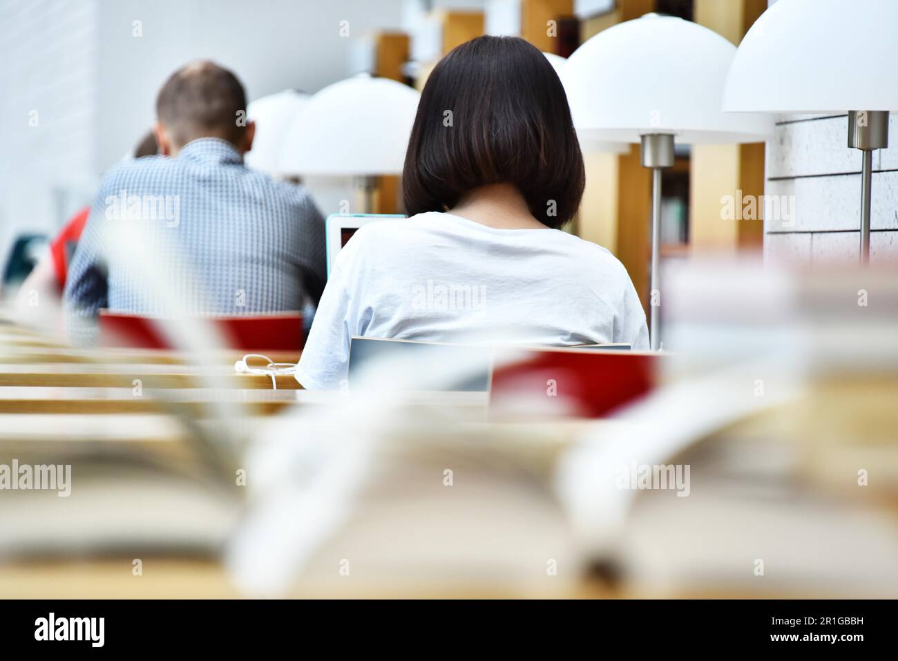 Gli studenti della lettura in una biblioteca pubblica Foto Stock