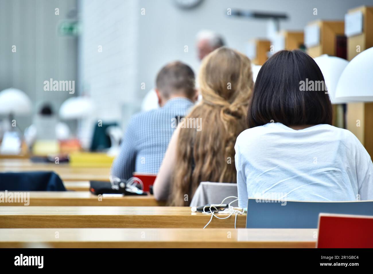 Gli studenti della lettura in una biblioteca pubblica Foto Stock