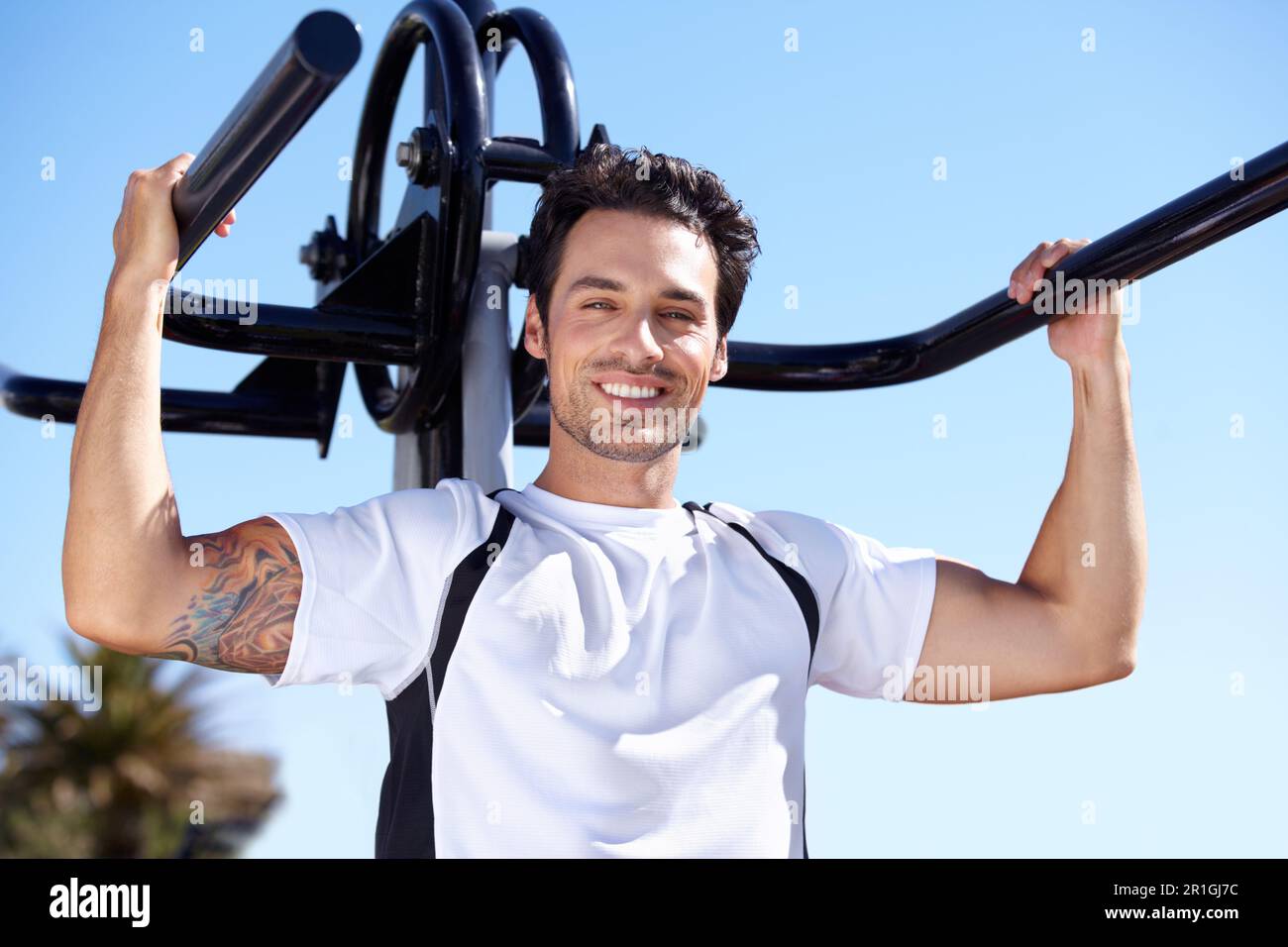 Uomo felice, fitness e ritratto con attrezzature presso la palestra del parco per allenarsi, allenarsi o allenarsi nella natura. Forma, attivo e forte maschio esercizio su Foto Stock