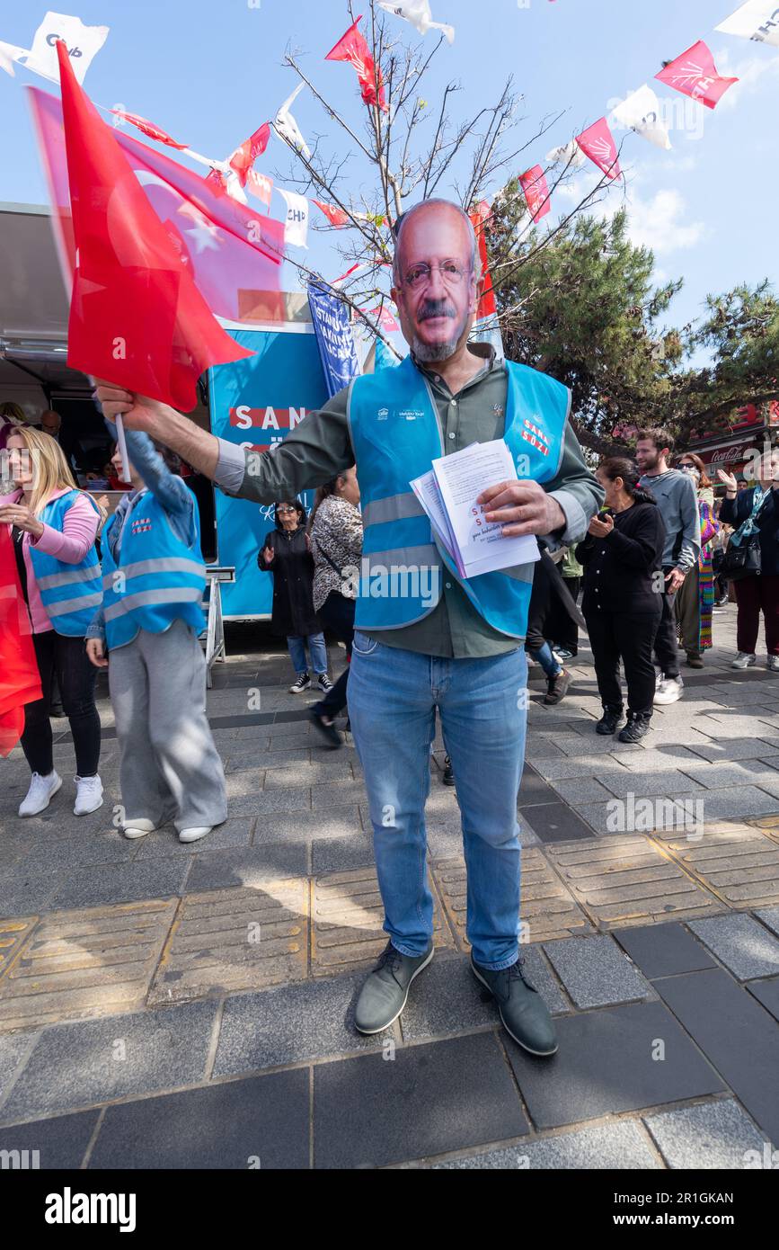 Istanbul, Turchia - Maggio 13 2023: Uomo che indossa una maschera di Kemal Kilicdaroglu di fronte al chiosco del Partito popolare Repubblicano nel quartiere di Uskudar durante le elezioni del 2023 Foto Stock