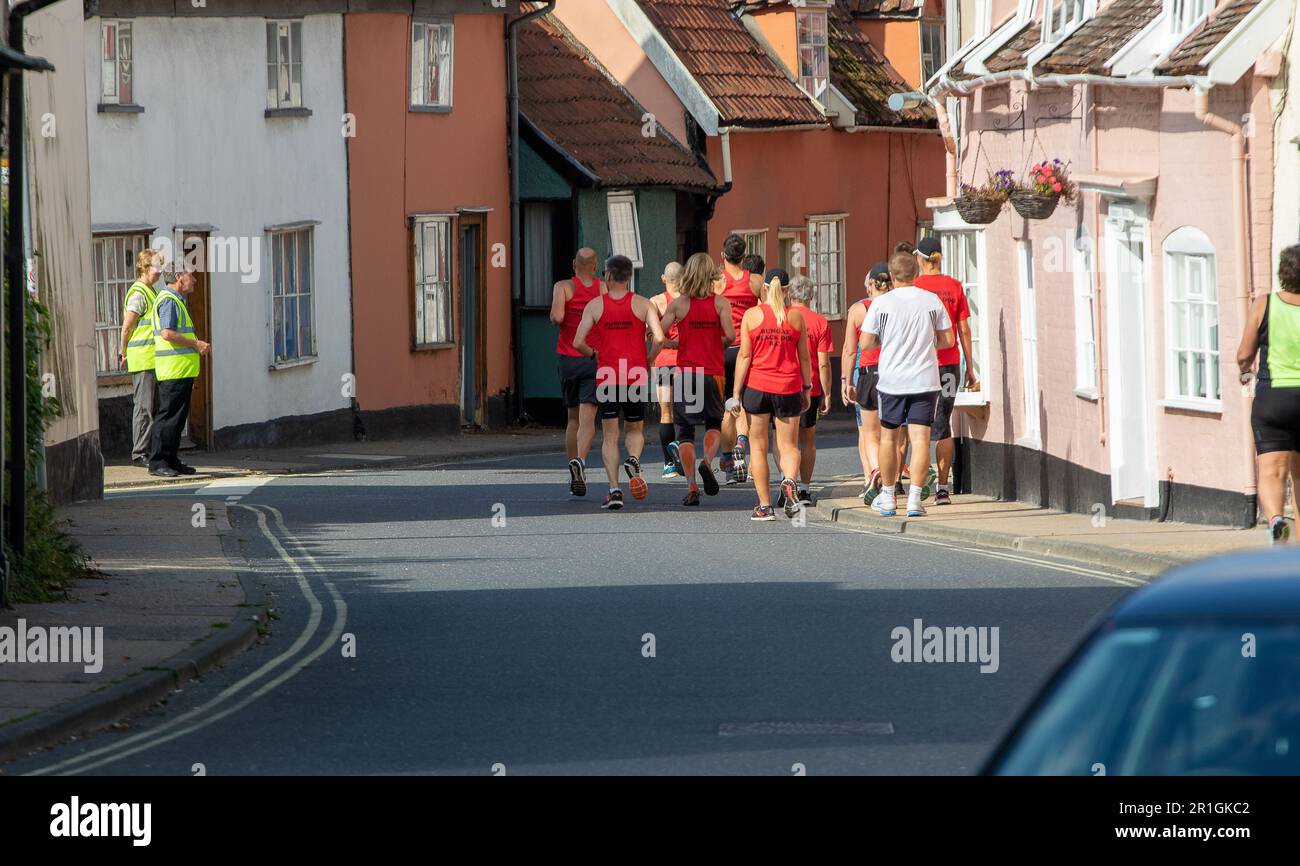 Runners on a Sunday walking from the clubhouse to the start of the Framlingham Flyer's 10km road race Foto Stock