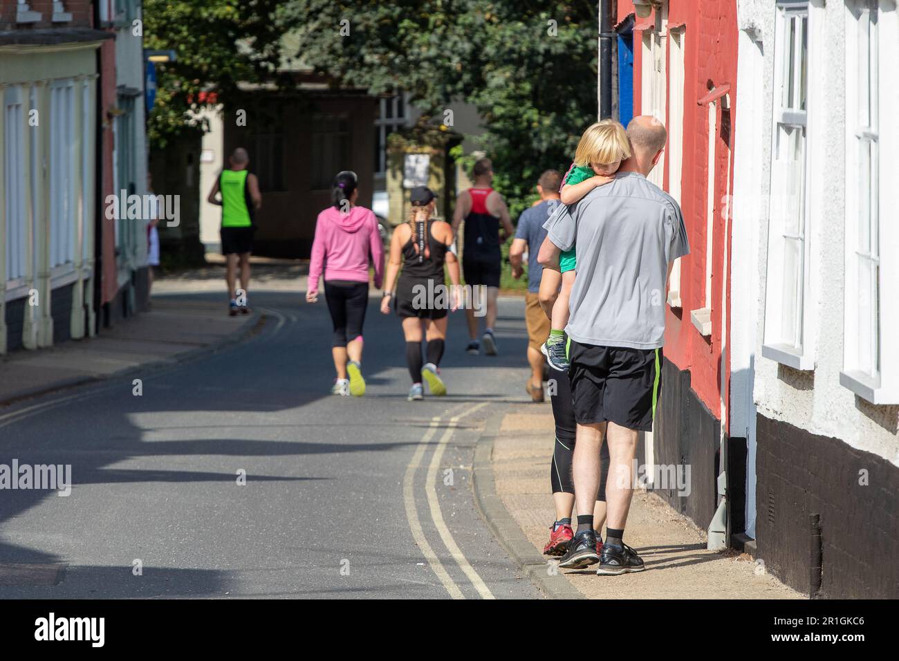 Runners on a Sunday walking from the clubhouse to the start of the Framlingham Flyer's 10km road race Foto Stock