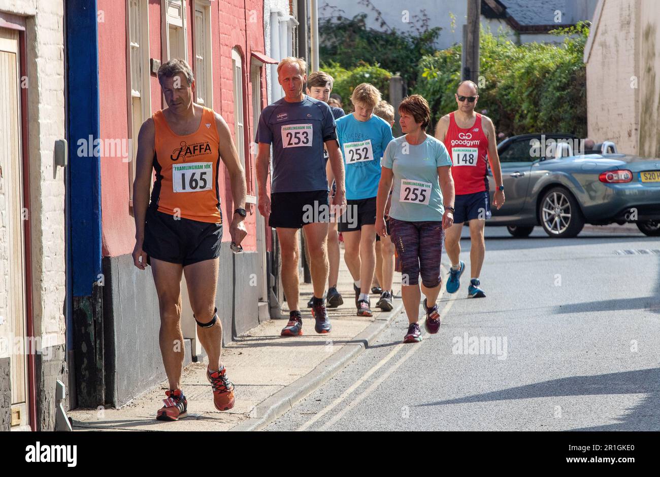 Runners on a Sunday walking from the clubhouse to the start of the Framlingham Flyer's 10km road race Foto Stock