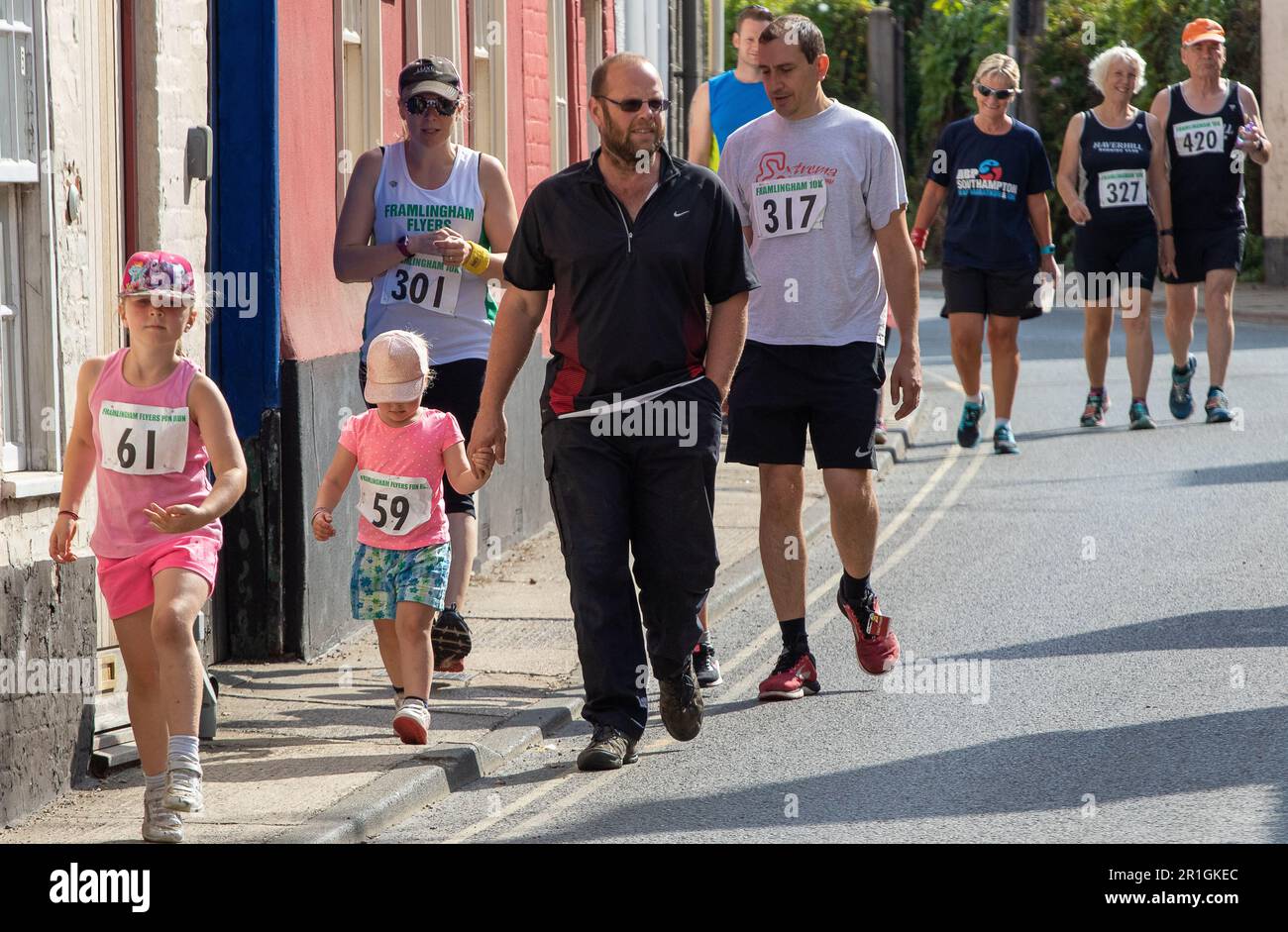 Runners on a Sunday walking from the clubhouse to the start of the Framlingham Flyer's 10km road race Foto Stock