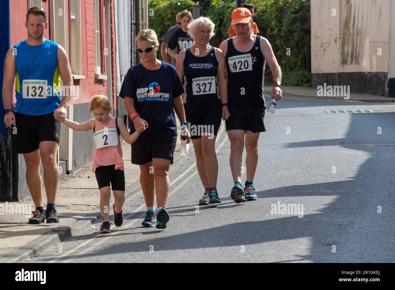 Runners on a Sunday walking from the clubhouse to the start of the Framlingham Flyer's 10km road race Foto Stock