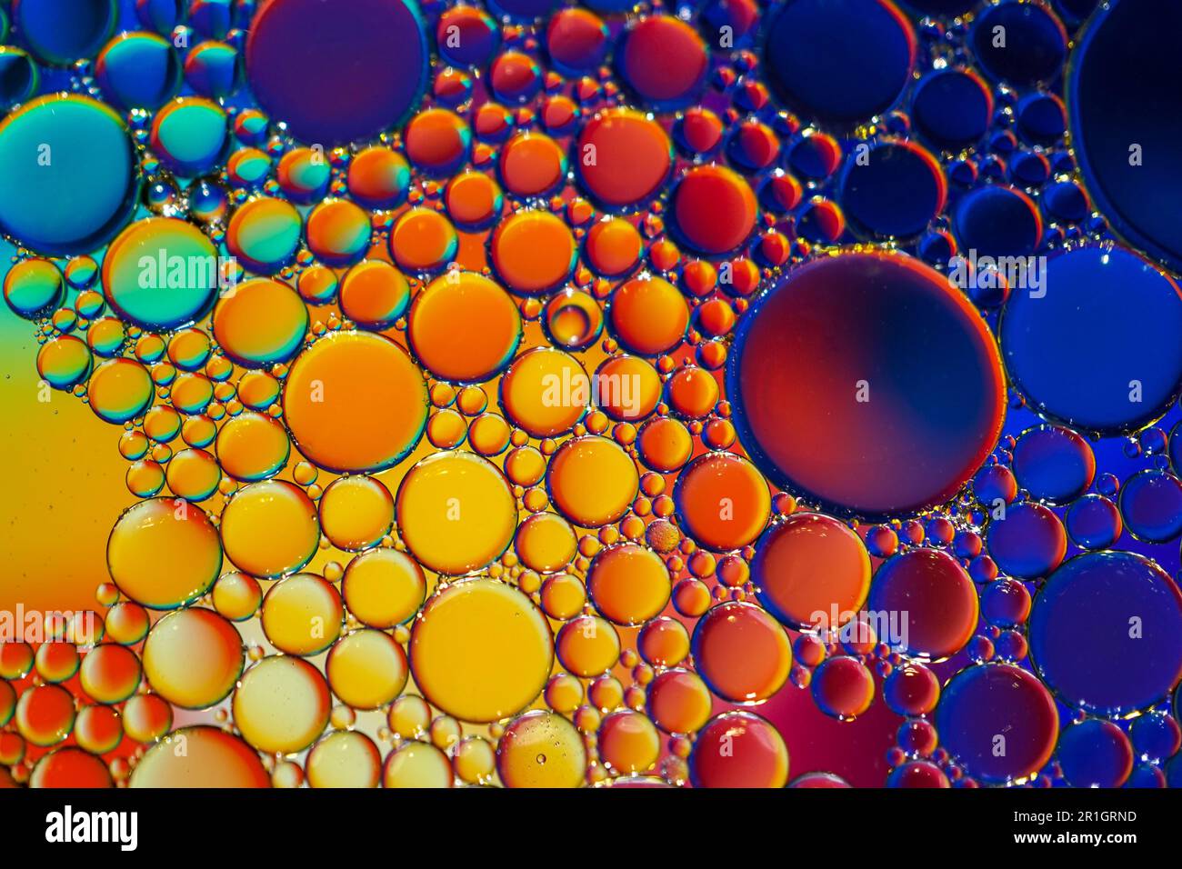 cerchi di olio multicolore sull'acqua, sfondo colorato Foto Stock