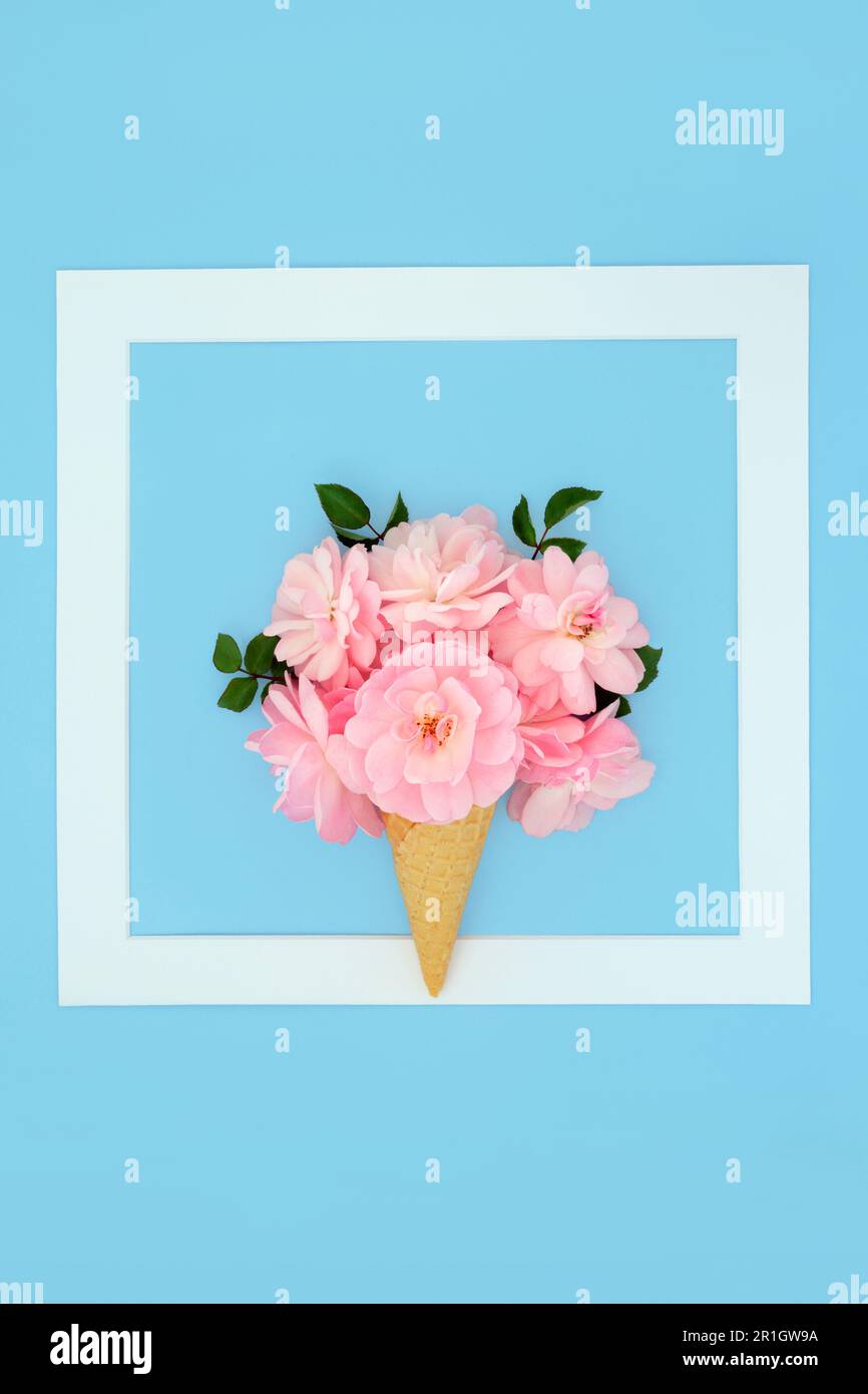 Fiore rosa surreale gelato cono design. Minimal estate bordo creativo logo floreale divertimento natura concetto. Su sfondo blu pastello con cornice bianca. Foto Stock