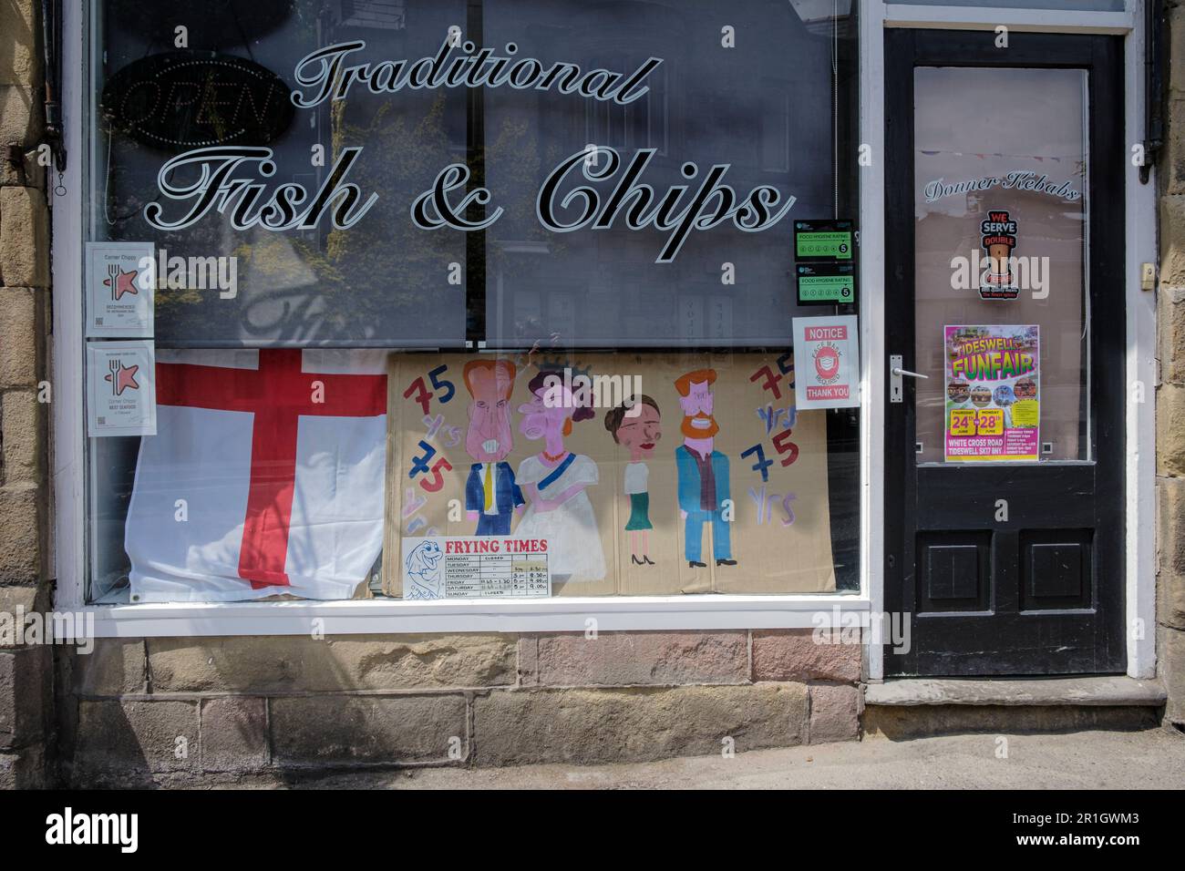 Mostra che segna il 75th° anniversario del VE Day nella vetrina di un negozio di pesce e chip a Tideswell, Derbyshire Foto Stock