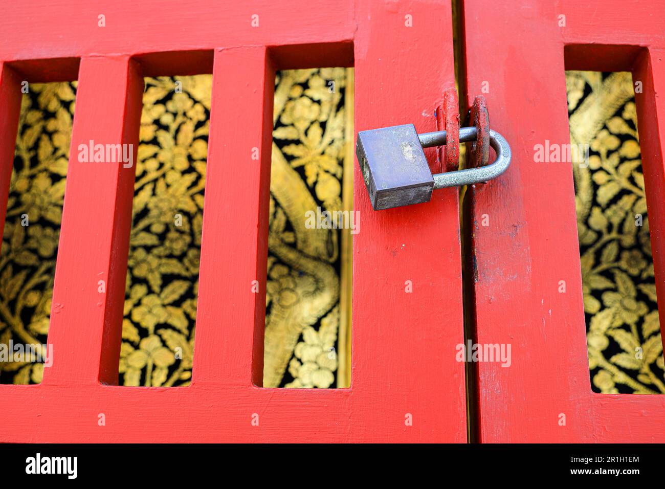 Porta in legno rosso con serratura per proteggere la porta tradizionale d'epoca in stile thailandese di lacca nera dorata ( Lai rot nam ). Foto Stock