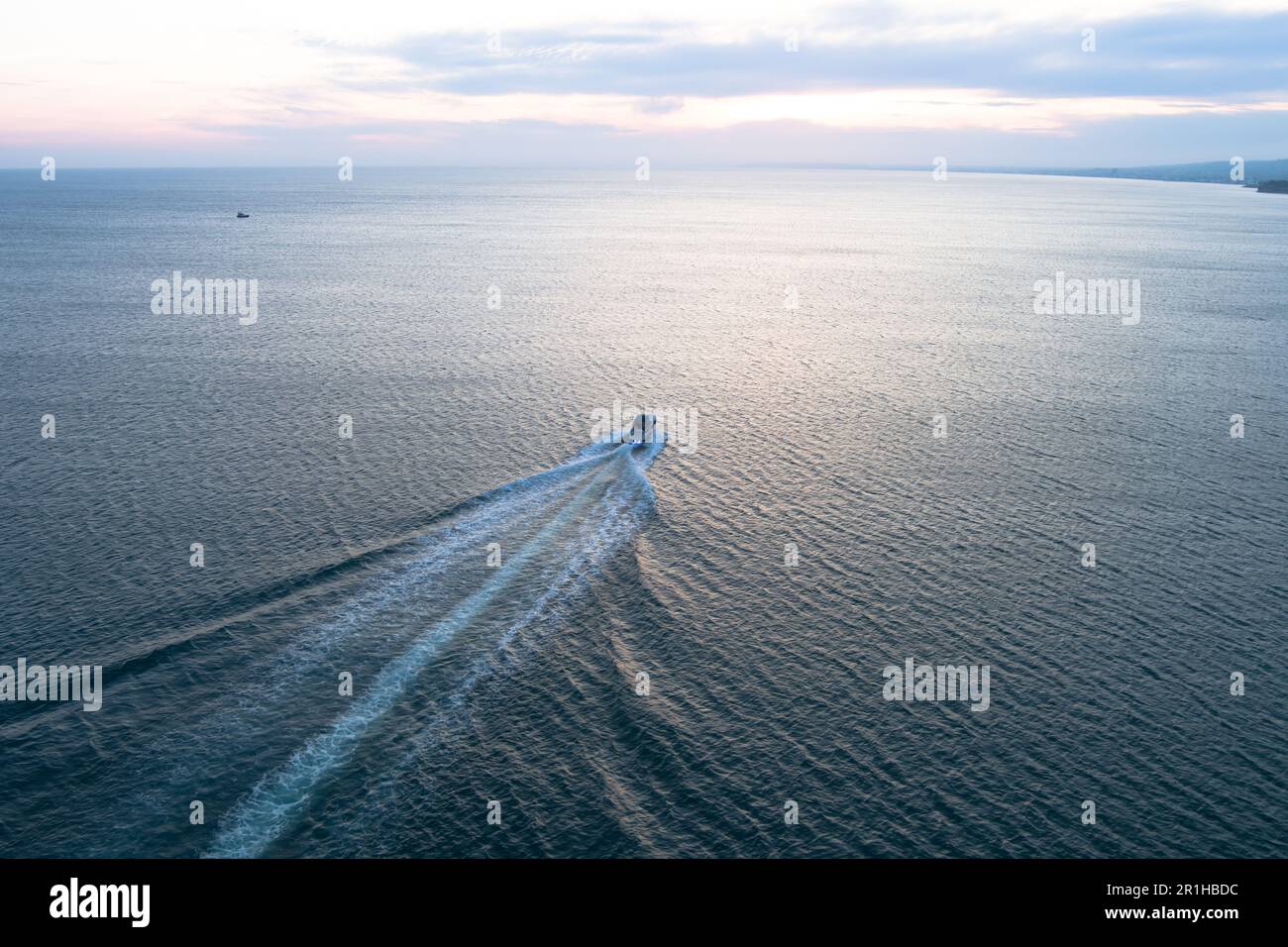 La barca va verso il tramonto; vista di un drone di una barca a vela; nautica in mare. Foto Stock