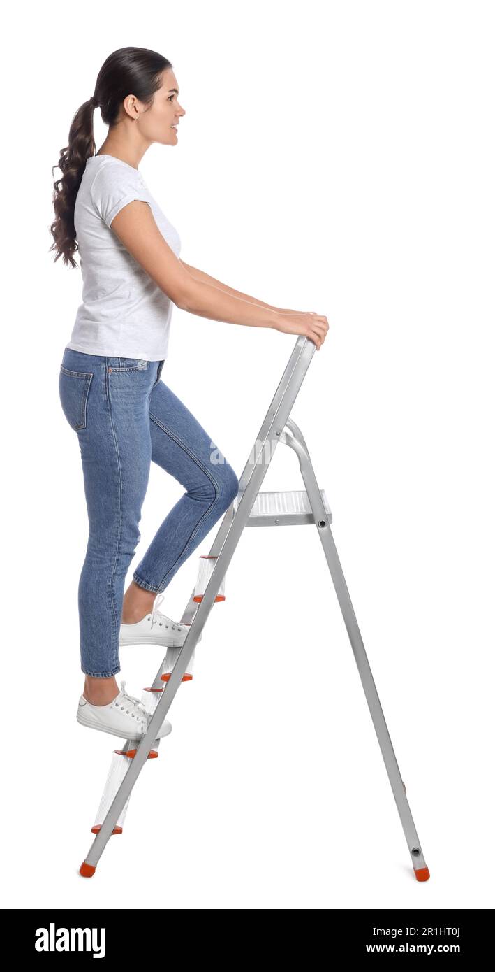 Giovane donna che sale su scala di metallo su sfondo bianco Foto Stock