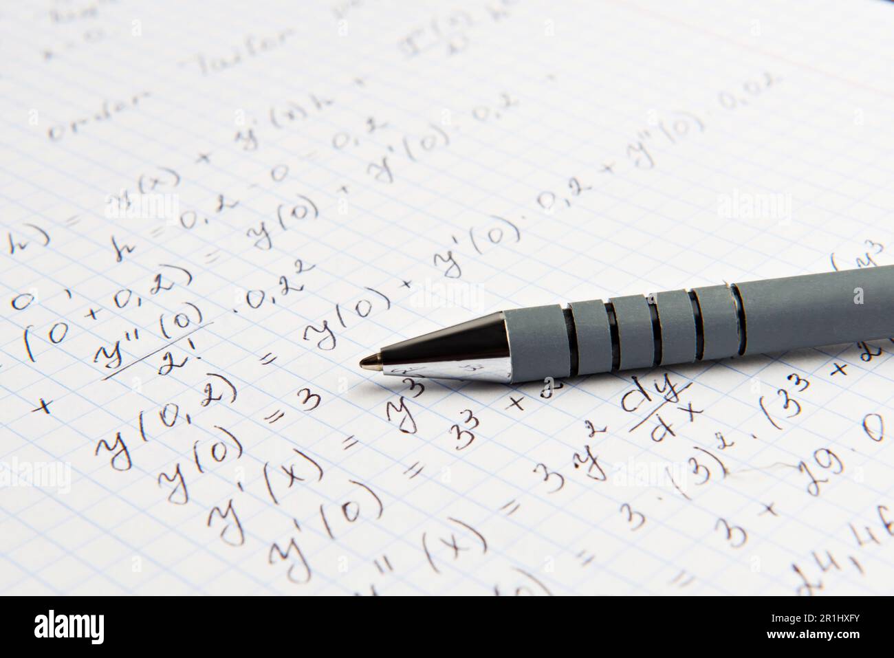 Carta con calcoli matematici scritti e penna, primo piano Foto Stock