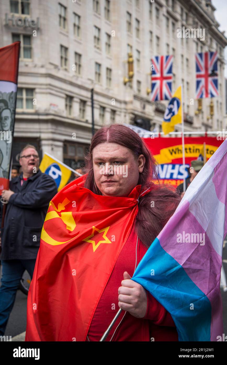 Persona trasportata nella bandiera comunista che porta la bandiera trans, rally del giorno internazionale dei lavoratori del maggio, Londra, Inghilterra, Regno Unito, 01/05/2023 Foto Stock